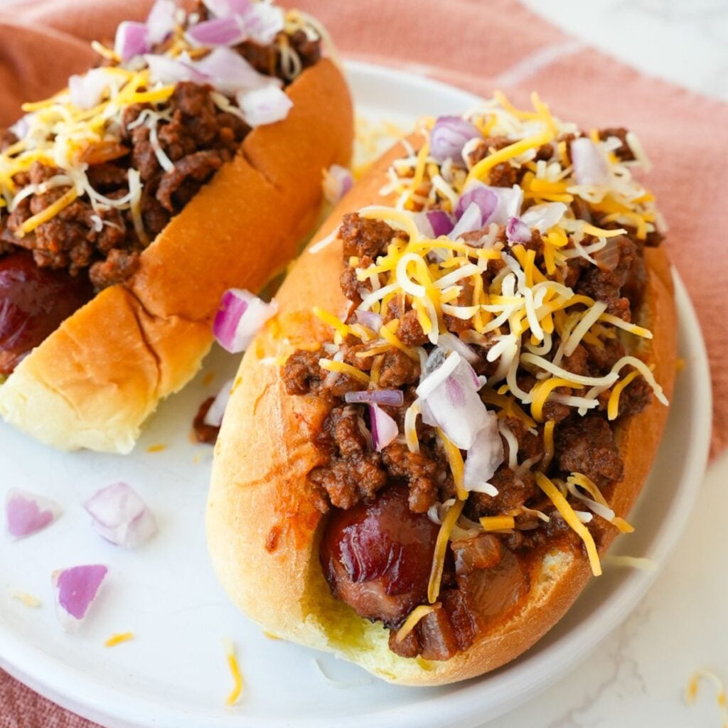 Hot dog topped with homemade chili, shredded cheese, and diced onions.