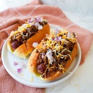 Hot dog topped with homemade chili, shredded cheese, and diced onions.