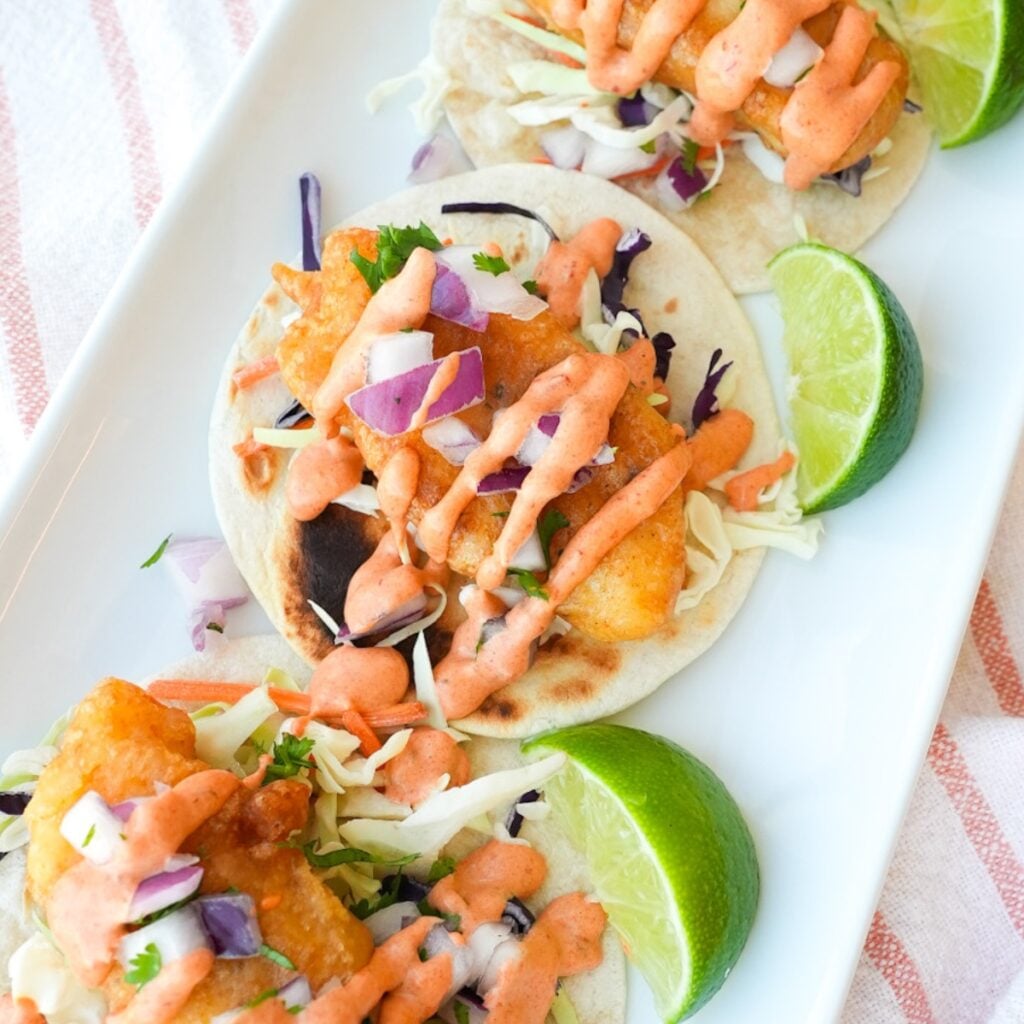 Baja fish tacos with crispy fried cod, shredded cabbage, diced red onion, cilantro, and chipotle mayo.
