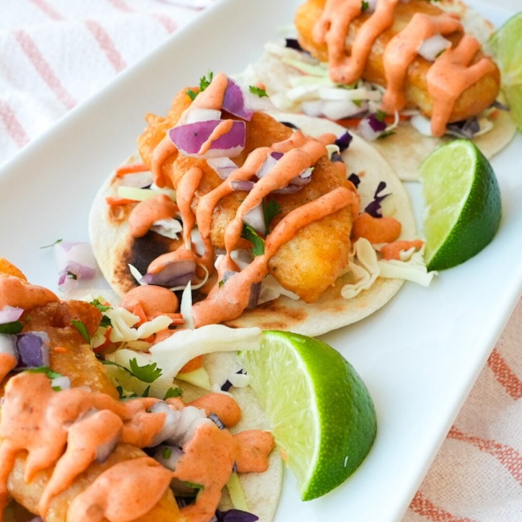 Baja fish tacos with crispy fried cod, shredded cabbage, diced red onion, cilantro, and chipotle mayo.
