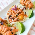 Baja fish tacos with crispy fried cod, shredded cabbage, diced red onion, cilantro, and chipotle mayo.