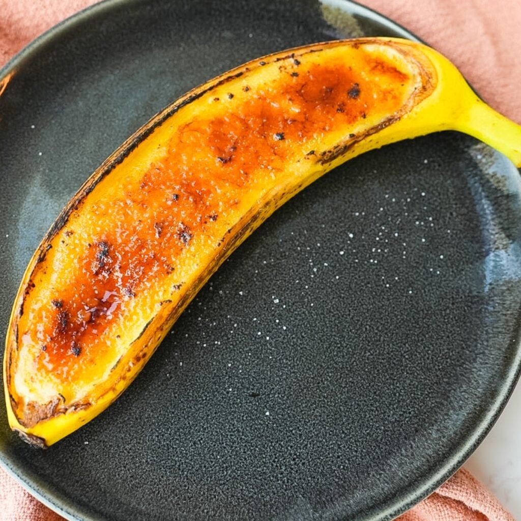 Banana creme brulee served inside banana peels with a caramelized sugar top.