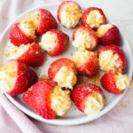 Fresh strawberries filled with cheesecake cream and topped with graham cracker crumbs.