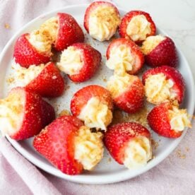 Fresh strawberries filled with cheesecake cream and topped with graham cracker crumbs.
