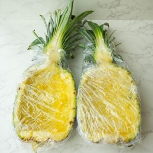 Pineapple boats wrapped in plastic wrap.