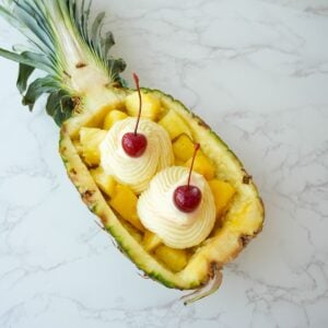 Copycat Dole Whip swirled inside a pineapple boat with a creamy soft serve texture.
