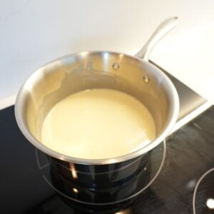Lemon posset filling in sauce pan on the stove.
