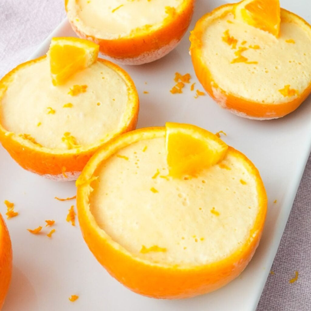 Frozen orange creamsicle cups served inside hollowed orange peels with a creamy orange filling.