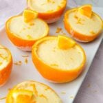 Frozen orange creamsicle cups served inside hollowed orange peels with a creamy orange filling.