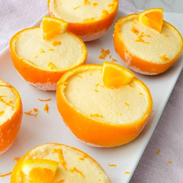 Frozen orange creamsicle cups served inside hollowed orange peels with a creamy orange filling.