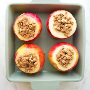 Apples stuffed with crisp topping in a baking dish.