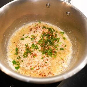 Breadcrumbs, parsley and red pepper flakes in a saucepan.