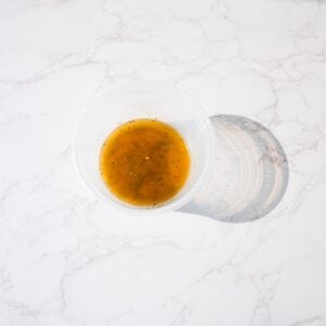 Herb butter melted in a container.