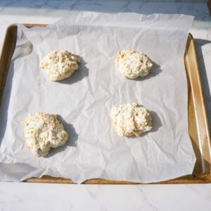 Cheddar bay biscuits on a baking tray before baking.