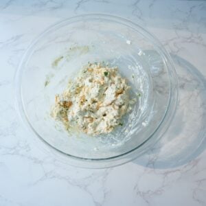 Cheddar bay biscuit dough in a glass mixing bowl.