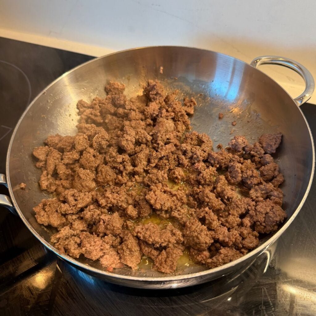 Ground beef browning in a pan.