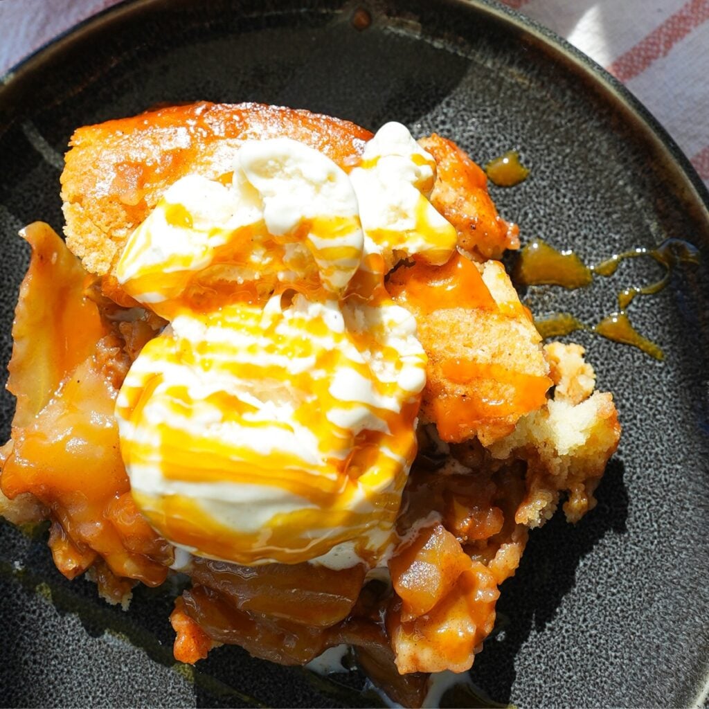 Warm apple cobbler with vanilla ice cream and caramel on top.