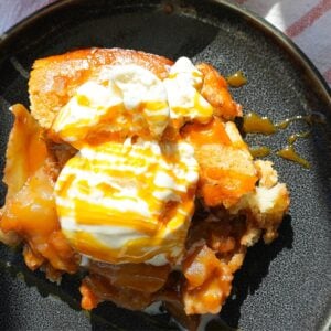 Warm apple cobbler with vanilla ice cream and caramel on top.