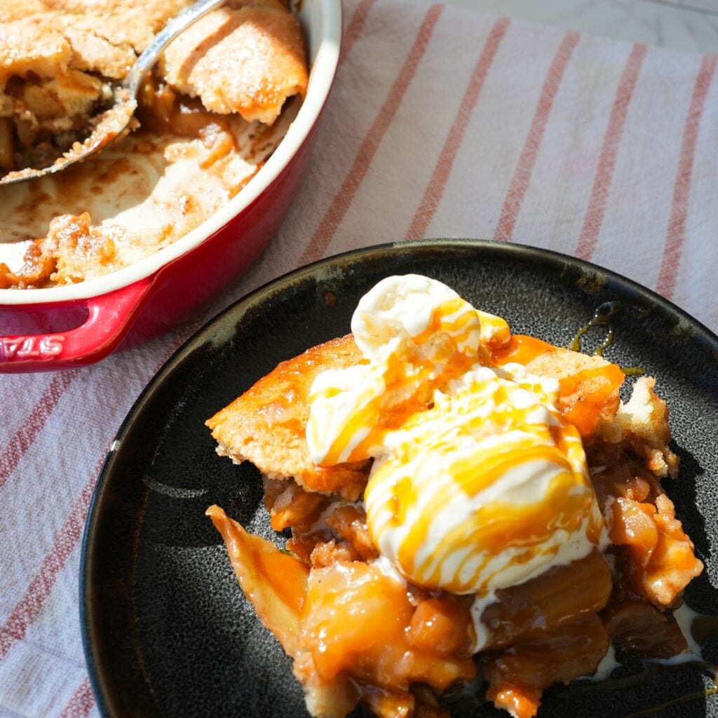 Warm apple cobbler with vanilla ice cream and caramel on top.