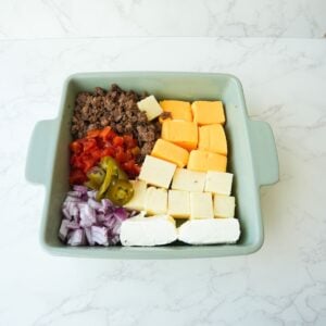 Ingredients for rotel dip in a baking dish before baking.