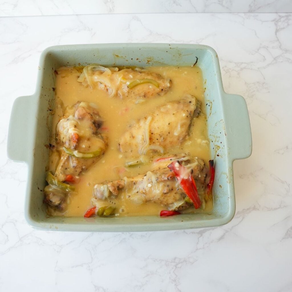 Turkey wings in a baking dish with gravy poured over.